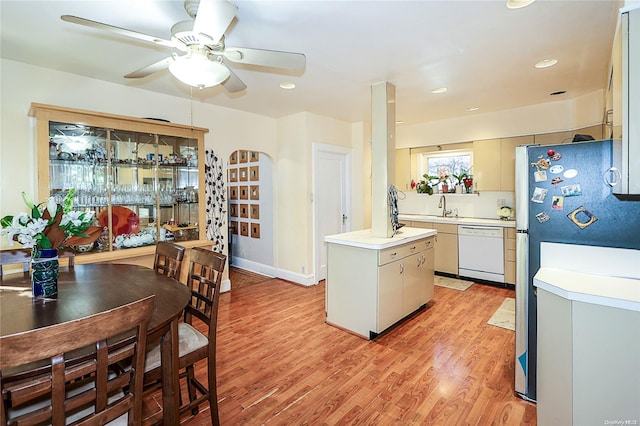 kitchen featuring dishwasher, a center island with sink, refrigerator, sink, and light hardwood / wood-style flooring