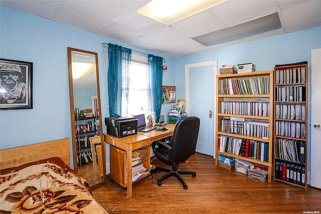 office area featuring a paneled ceiling and hardwood / wood-style flooring