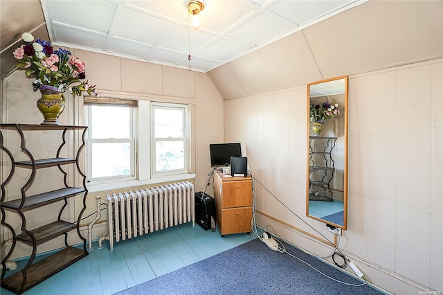 office featuring wood-type flooring, lofted ceiling, and radiator