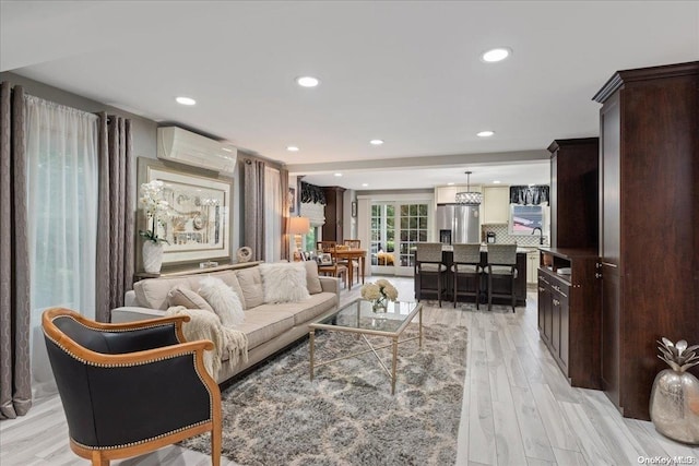 living room with a wall mounted air conditioner and light hardwood / wood-style flooring