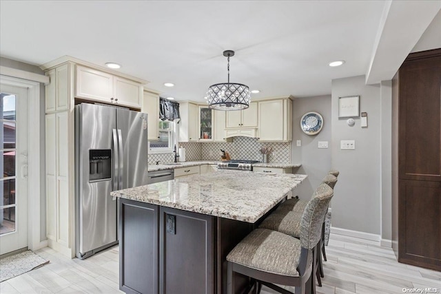 kitchen featuring pendant lighting, plenty of natural light, a center island, and stainless steel appliances