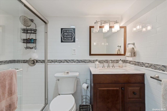 bathroom featuring vanity, toilet, tile walls, and walk in shower