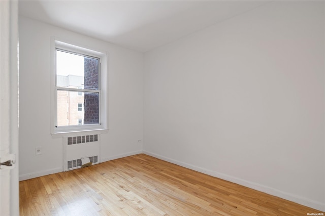 unfurnished room featuring light hardwood / wood-style floors and radiator