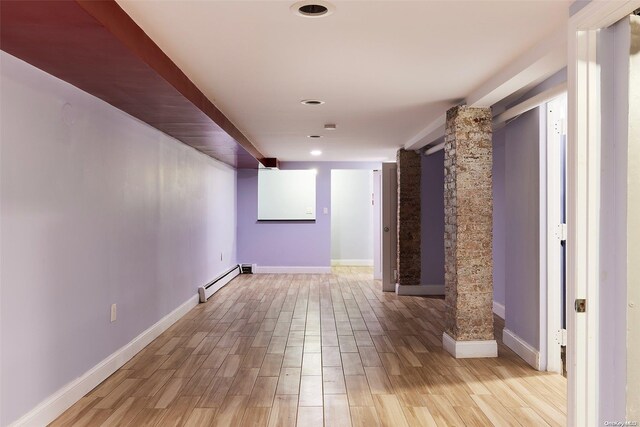 corridor featuring light hardwood / wood-style floors, ornate columns, and baseboard heating