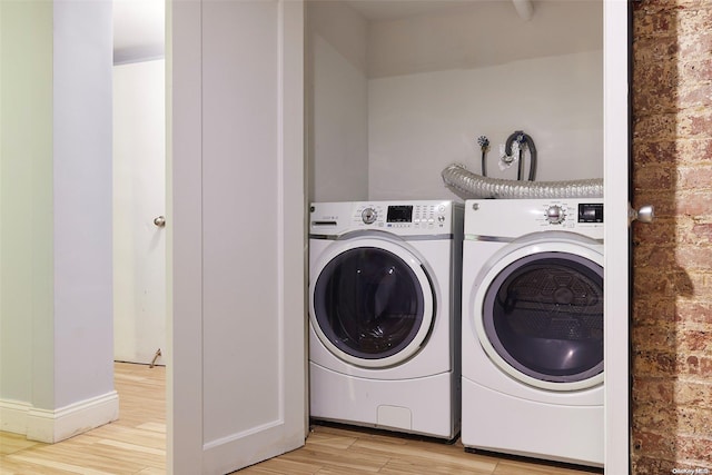 laundry room with light hardwood / wood-style floors and washer and clothes dryer