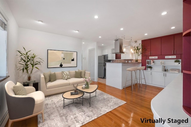 living room featuring light hardwood / wood-style flooring and a baseboard heating unit