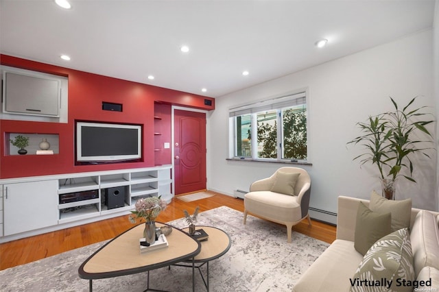 living room featuring light hardwood / wood-style floors and a baseboard heating unit