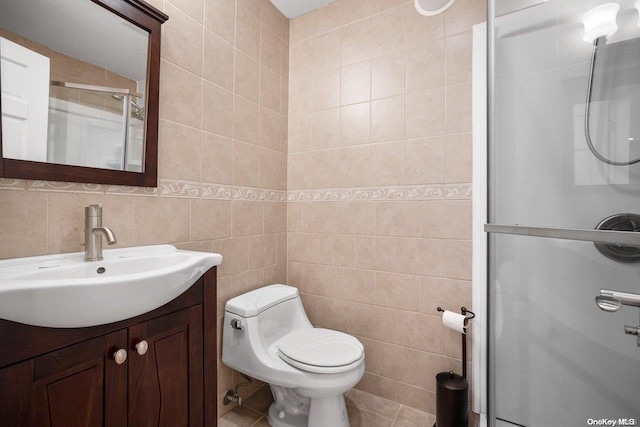 bathroom featuring vanity, a shower with shower door, tile walls, and toilet