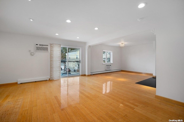 unfurnished room featuring a wall mounted AC, light hardwood / wood-style floors, and a baseboard radiator