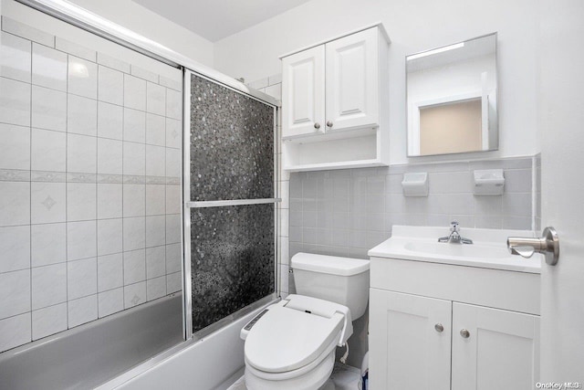 full bathroom featuring tasteful backsplash, combined bath / shower with glass door, toilet, vanity, and tile walls