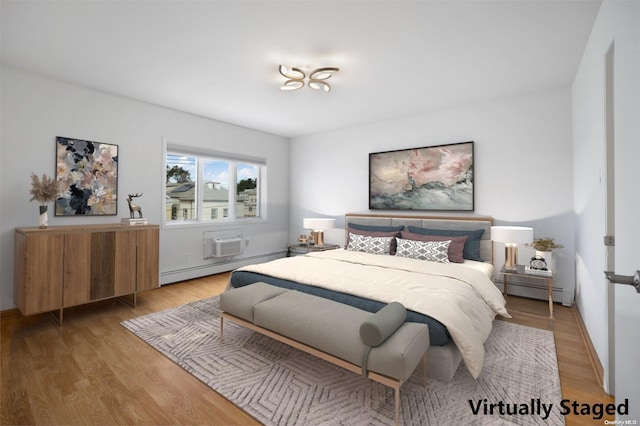 bedroom with light hardwood / wood-style floors, an AC wall unit, and baseboard heating