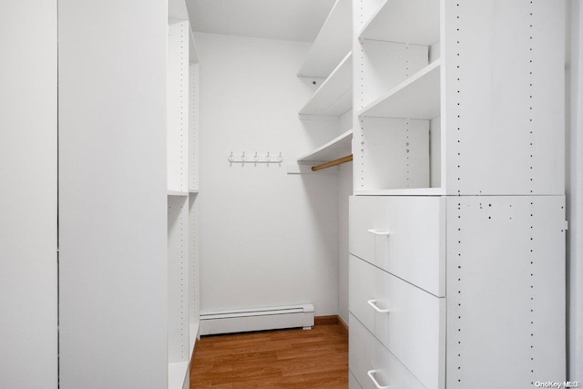 walk in closet featuring hardwood / wood-style floors and baseboard heating