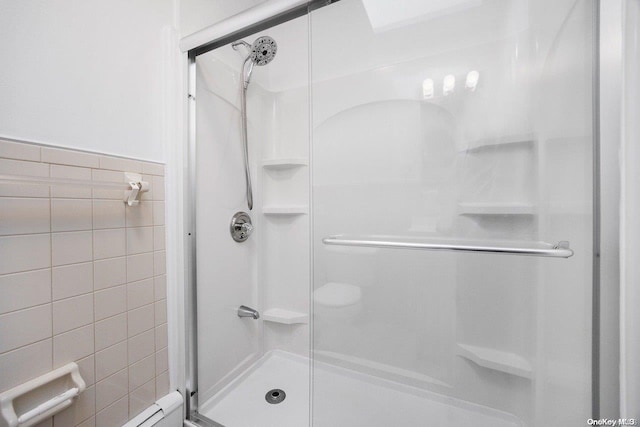 bathroom featuring an enclosed shower and tile walls