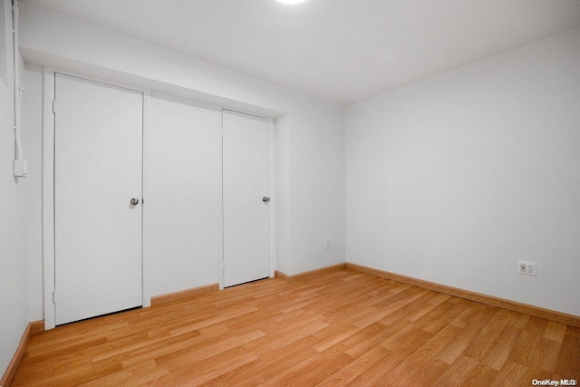 unfurnished bedroom featuring light hardwood / wood-style flooring and a closet