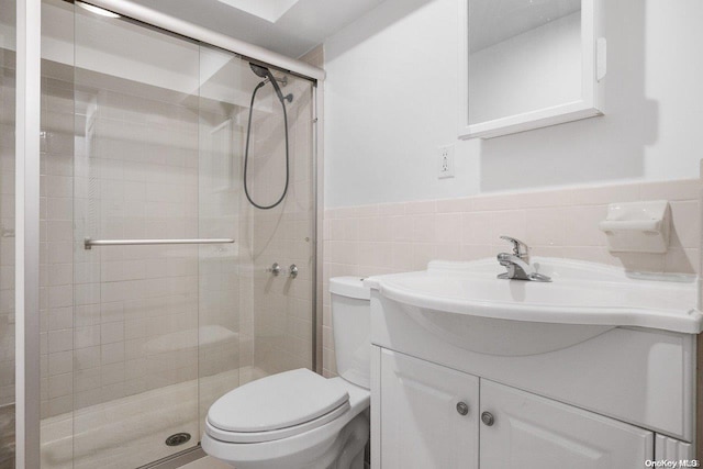 bathroom with vanity, an enclosed shower, tile walls, and toilet