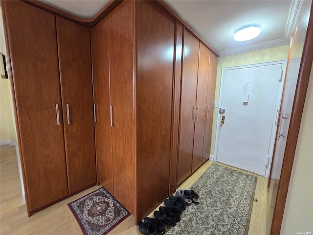 interior space with light wood-type flooring and crown molding