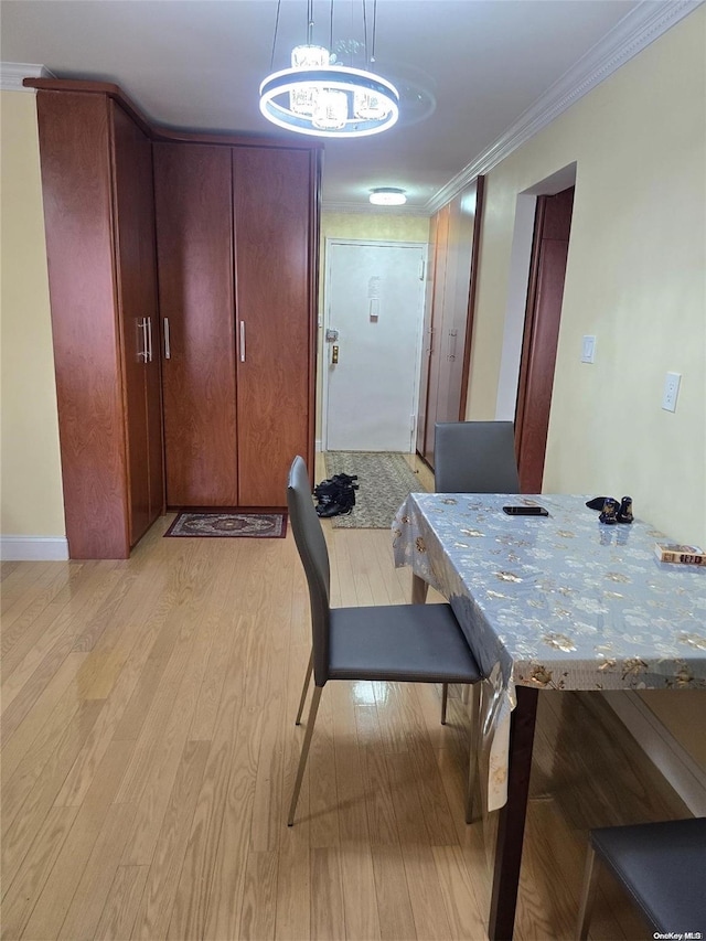 dining area featuring a chandelier, crown molding, and light hardwood / wood-style floors