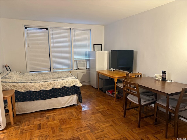 bedroom with dark parquet floors and cooling unit