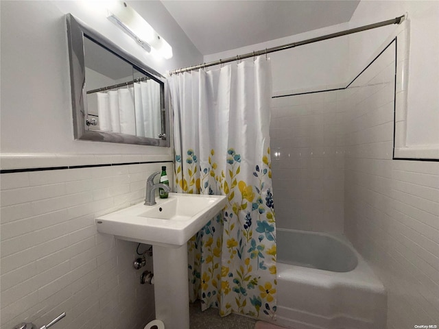 bathroom with tile walls and shower / tub combo