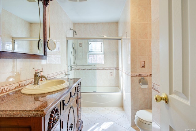 full bathroom with tile patterned floors, vanity, tile walls, and combined bath / shower with glass door