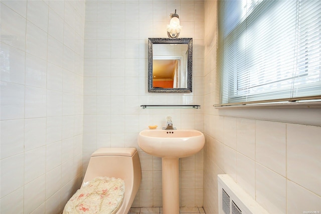 bathroom with toilet and tile walls