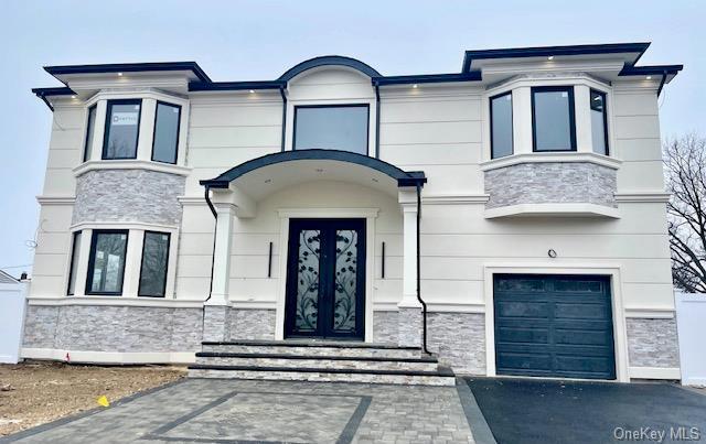 entrance to property with a garage and stone siding