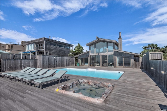 view of swimming pool featuring a deck and an in ground hot tub