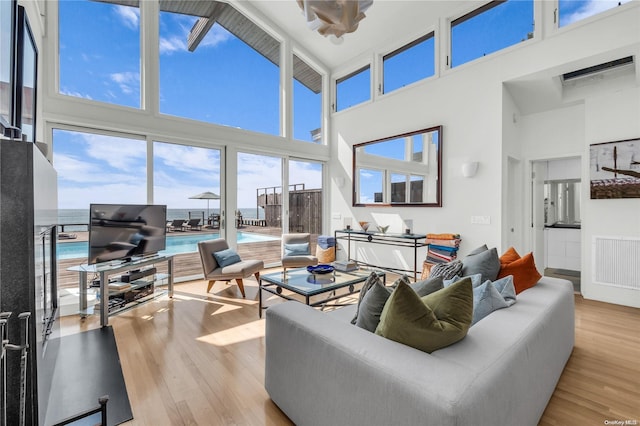 living room featuring a high ceiling and light wood-type flooring