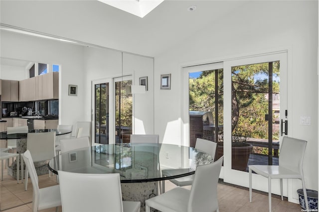 dining area with light tile patterned floors and lofted ceiling