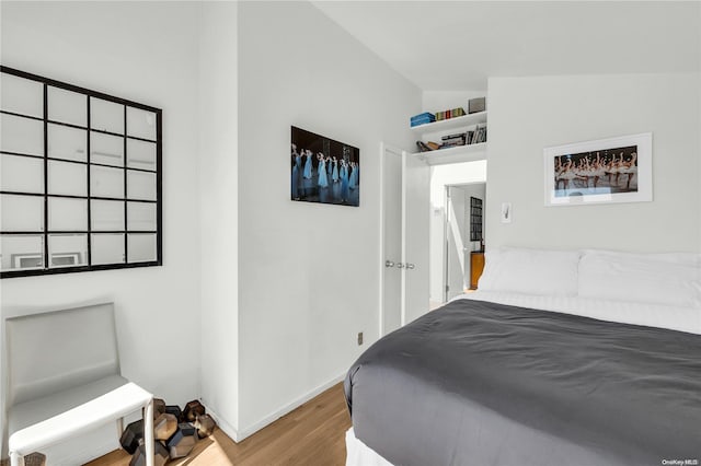 bedroom with hardwood / wood-style flooring and vaulted ceiling