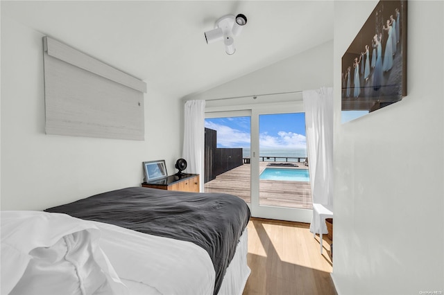 bedroom featuring access to exterior, wood-type flooring, and vaulted ceiling