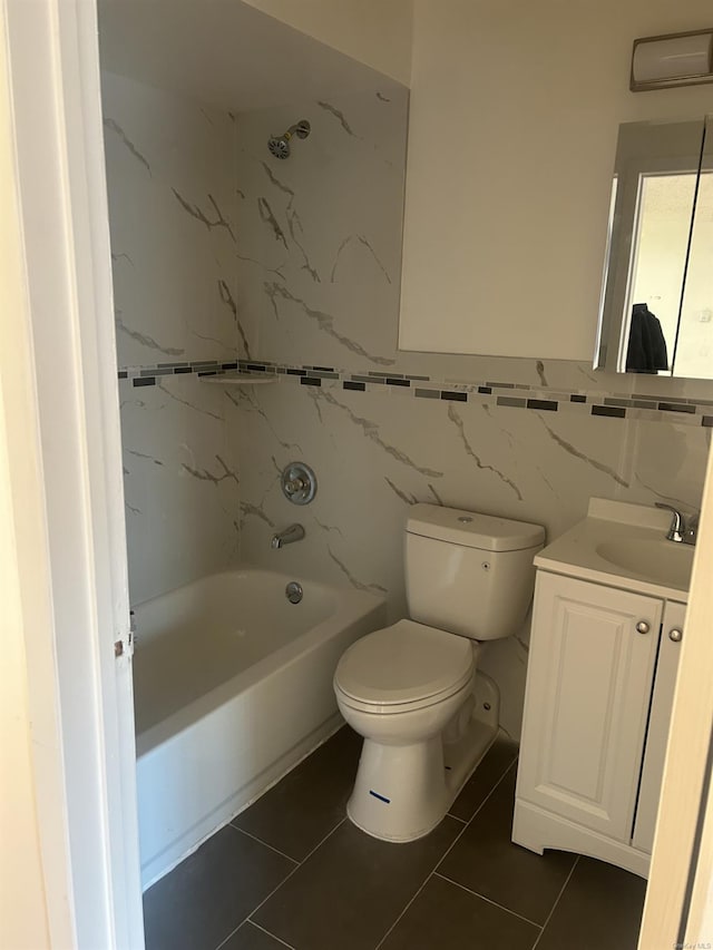 full bathroom featuring tile patterned flooring, toilet, vanity, tile walls, and tiled shower / bath