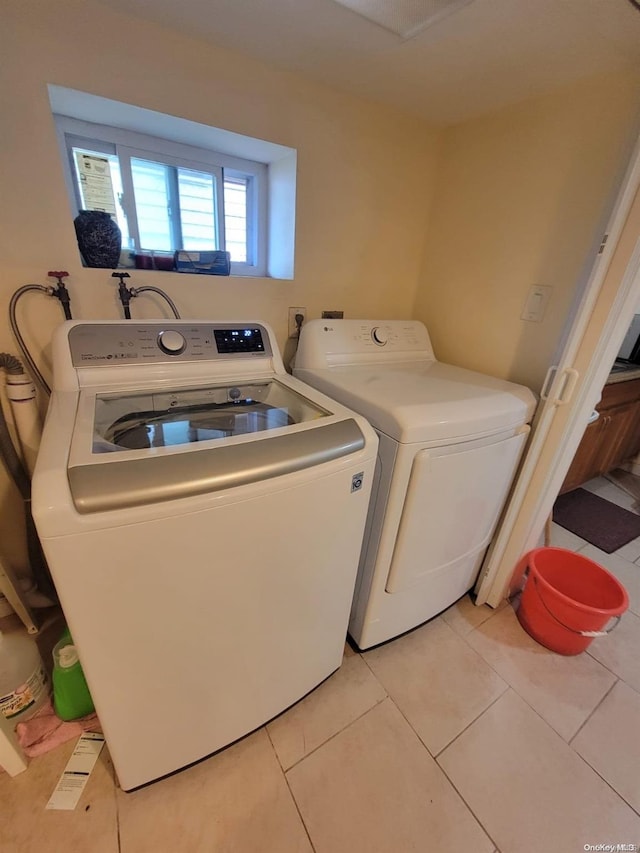 laundry room featuring washing machine and dryer and light tile patterned floors