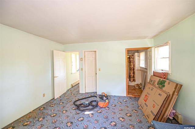 bedroom with carpet flooring and a baseboard heating unit