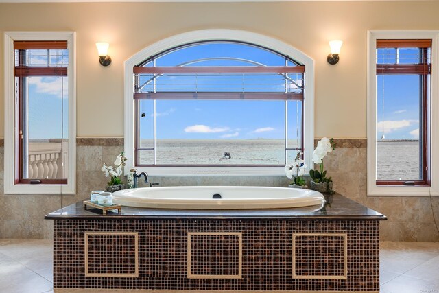 bathroom featuring tile walls, tile patterned flooring, and tiled tub