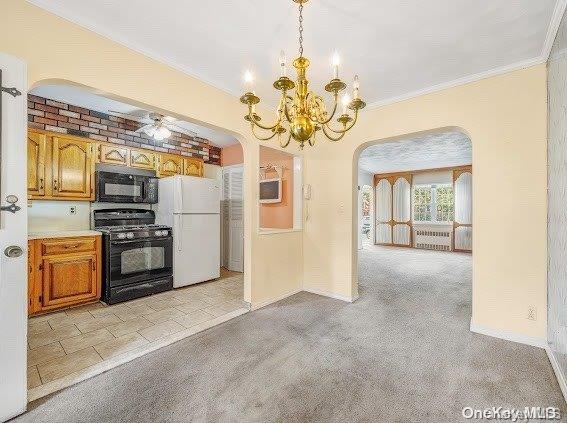 kitchen featuring pendant lighting, light colored carpet, crown molding, and black appliances