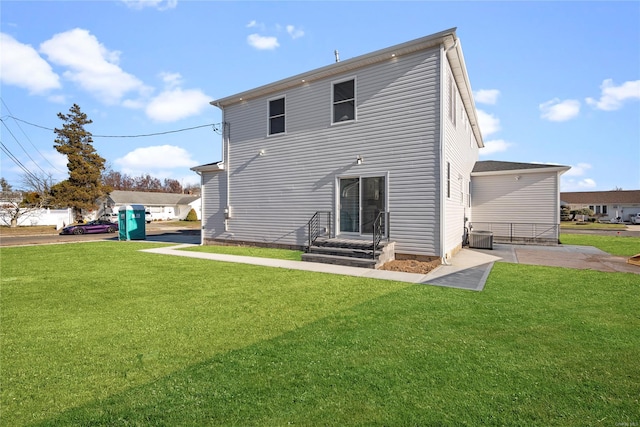 rear view of property with a yard and central AC unit