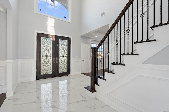 foyer with french doors and a high ceiling