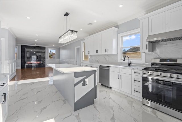 kitchen with a center island, white cabinets, hanging light fixtures, and appliances with stainless steel finishes