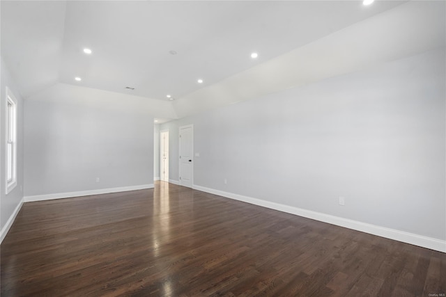 empty room with vaulted ceiling and dark wood-type flooring