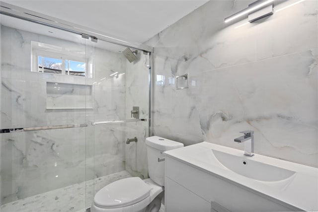 bathroom featuring vanity, toilet, and a shower with shower door