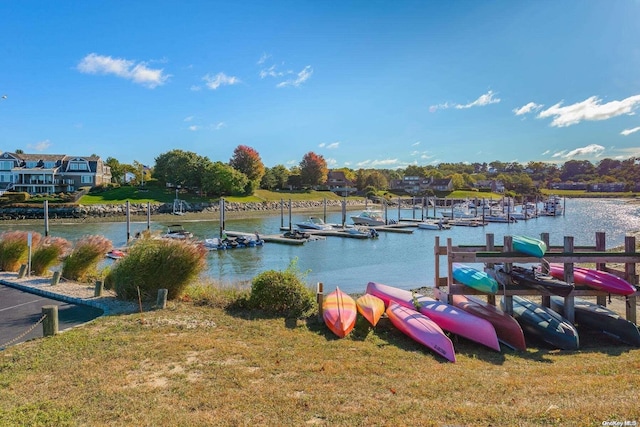 view of dock with a water view and a lawn