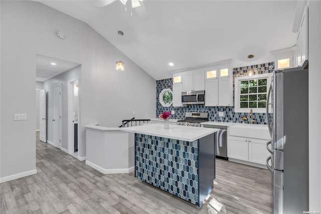 kitchen with light hardwood / wood-style flooring, white cabinets, lofted ceiling, and appliances with stainless steel finishes