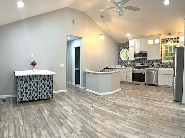 kitchen with white cabinetry, light hardwood / wood-style flooring, stainless steel appliances, and vaulted ceiling