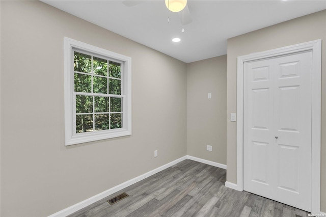 unfurnished bedroom with hardwood / wood-style floors, ceiling fan, and a closet