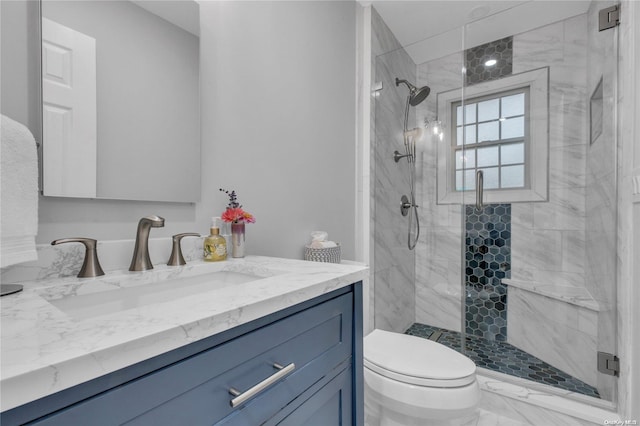 bathroom featuring vanity, toilet, and a shower with door