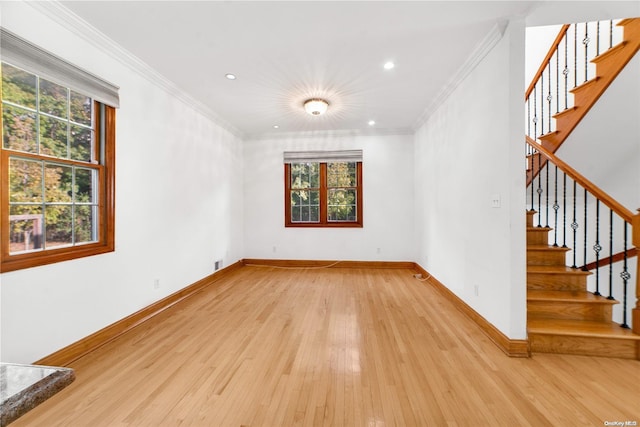 spare room featuring light hardwood / wood-style floors and ornamental molding