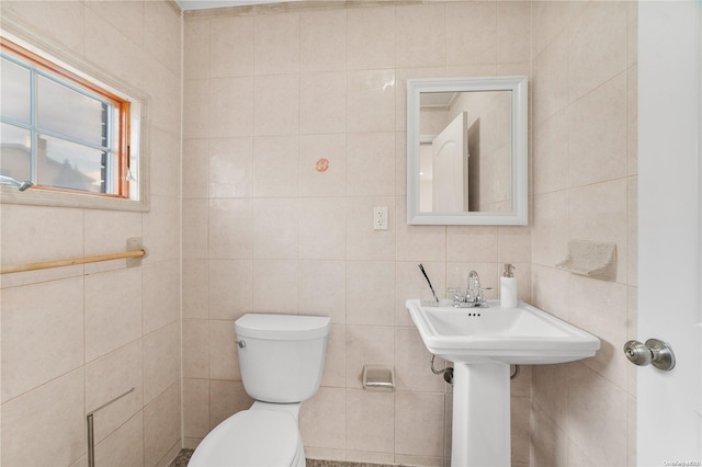 bathroom featuring toilet and tile walls