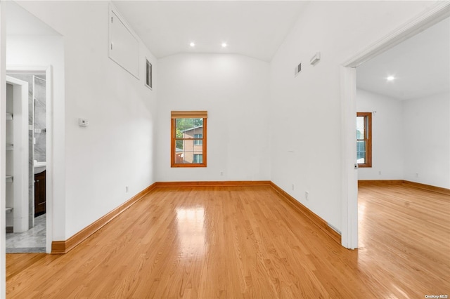 unfurnished room featuring light wood-type flooring and vaulted ceiling