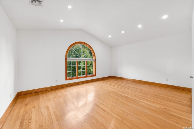 empty room with lofted ceiling and light hardwood / wood-style flooring